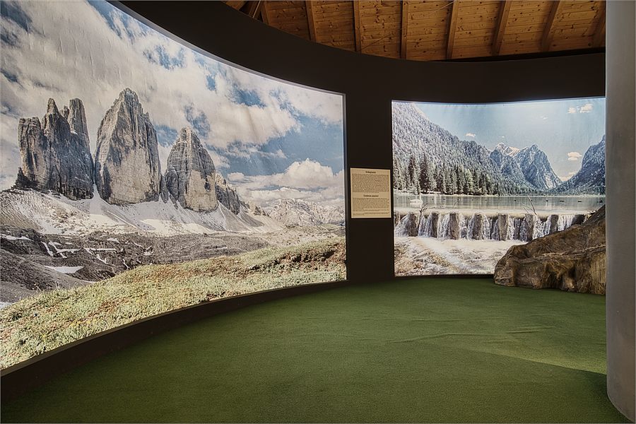 Il grande pannello delle Tre Cime nella sala espositiva di Mondolatte, davanti i vecchi attrezzi